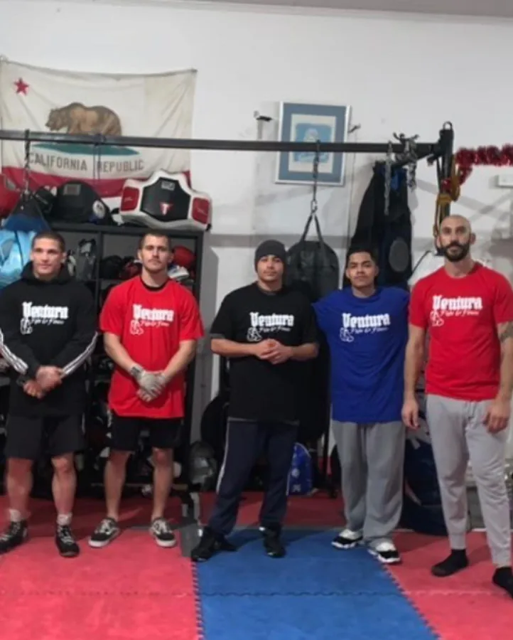 Coaches and members lined up in Ventura Fight & Fitness shirts on the gym floor